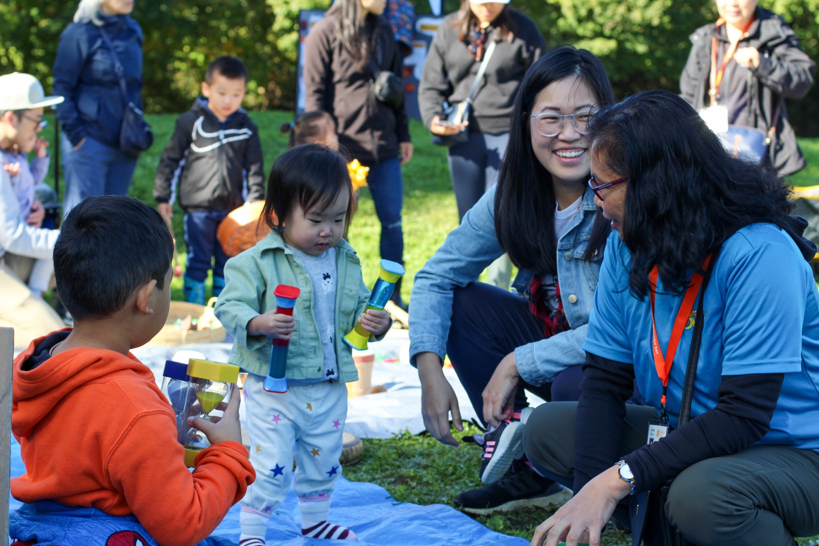 Staff, parent and children playing in park